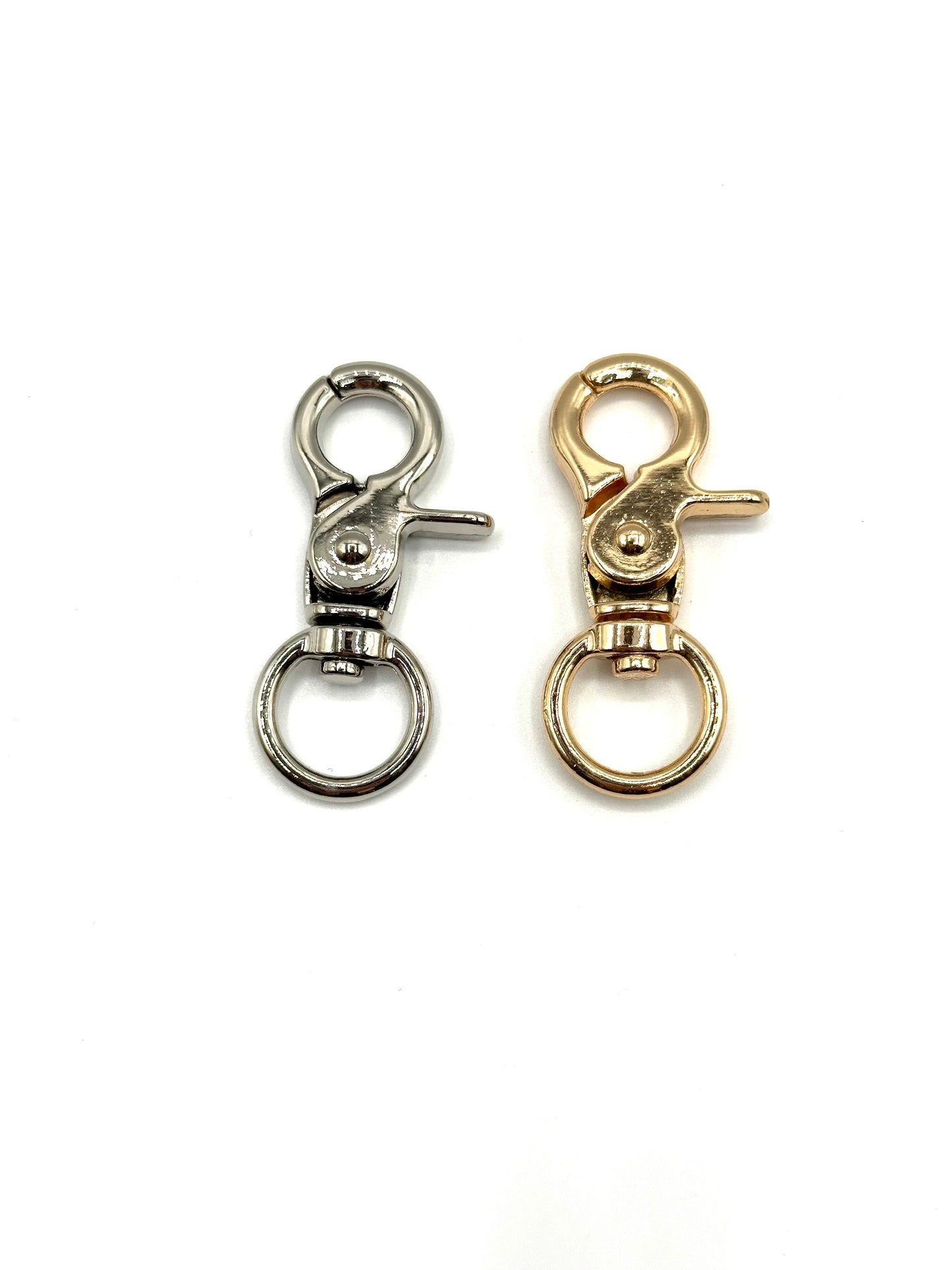 silver and golden swivel clasps on white background