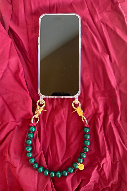 Transparent Phone case with green beaded chain on a red fabric background